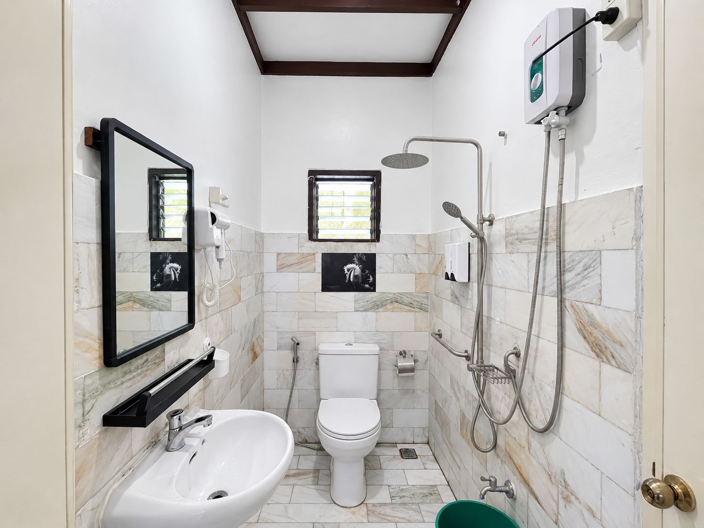 Un baño con inodoro, bidé, lavamanos y ducha.
