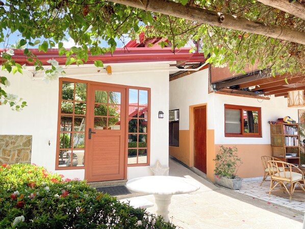 A house with a wooden door, a window, a balcony, and a table.
