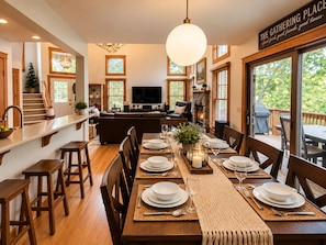 A dining area with a wooden table set for six, a fireplace, and a television in the background. - 4BR Poconos Retreat, Fall at Camelback (Tannersville)