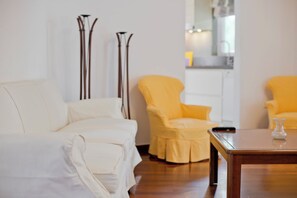 A living room with a white sofa, a yellow armchair, and a wooden coffee table. - Casa  Luma (Marousi)