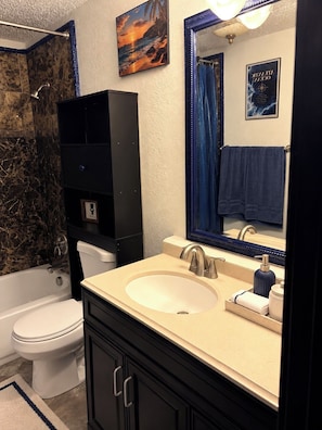 A bathroom with a bathtub, toilet, sink, and a large mirror. - The Worldhouse: A Unique Travel-Themed Stay Near Seattle (Renton)