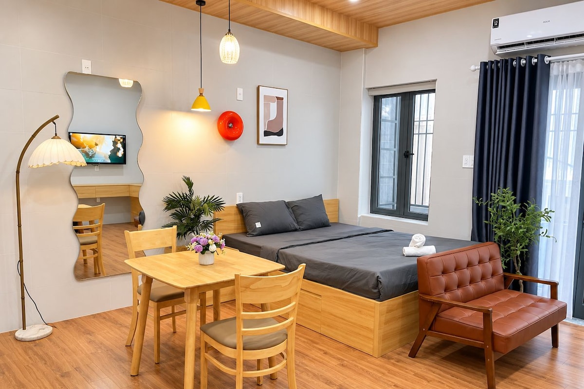 Una habitación de hotel pequeña con una cama, un escritorio, una silla, una mesa y un televisor.