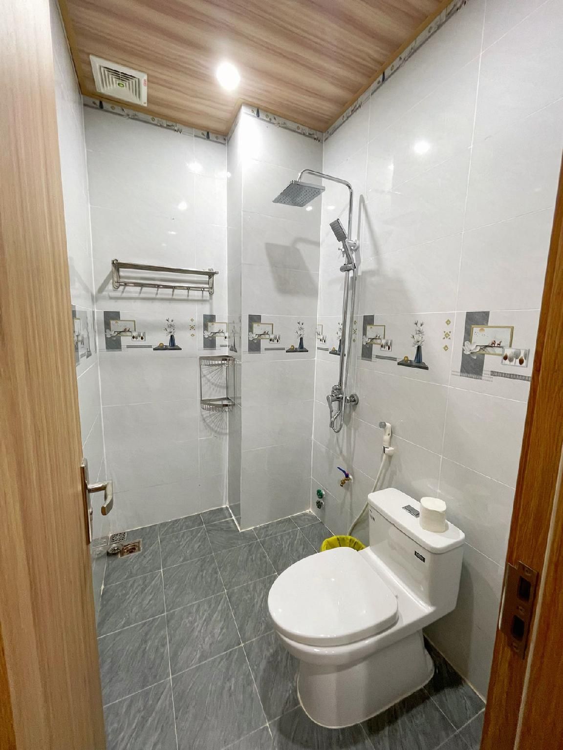 Un baño moderno con ducha, inodoro y perchero.