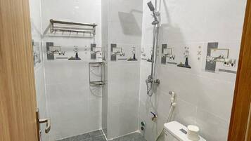 Un baño moderno con ducha, inodoro y perchero.