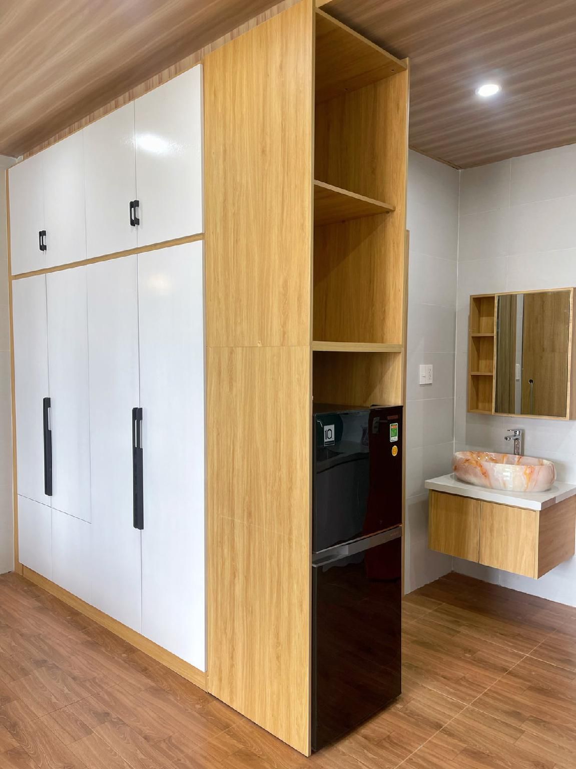 Una habitación con armario, espejo y lavabo.