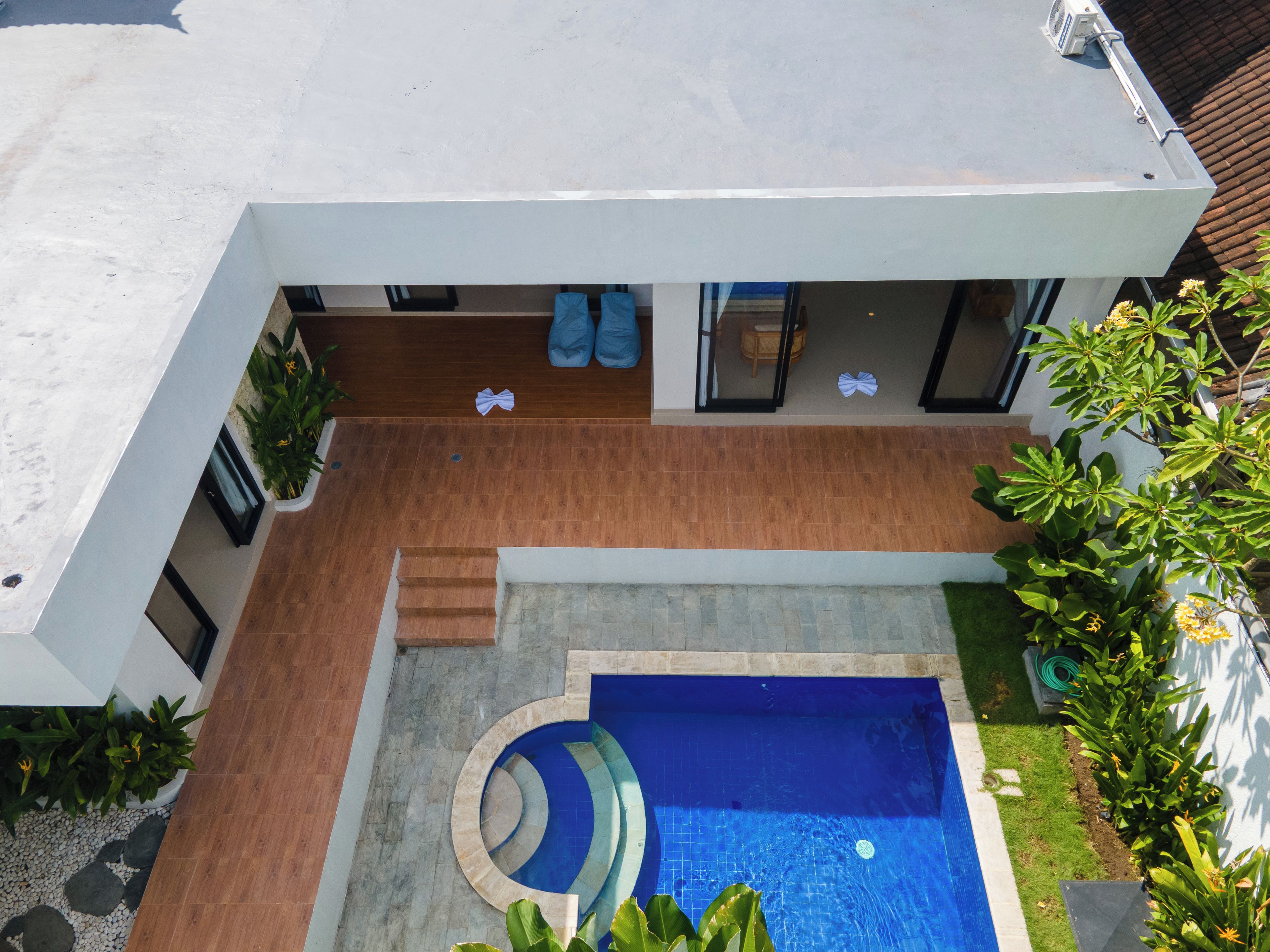 A modern house with a swimming pool, a patio area, and a garden.