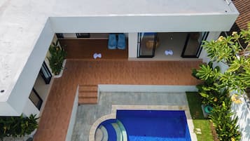 A modern house with a swimming pool, a patio area, and a garden.