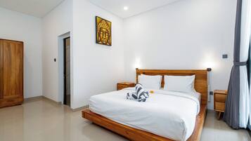 A hotel room with a wooden bed, white linens, a nightstand, a wardrobe, and a wall-mounted artwork.