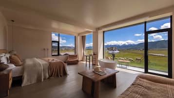 A spacious living room with a large window offering a mountain view, a cozy seating area, and a wooden coffee table.