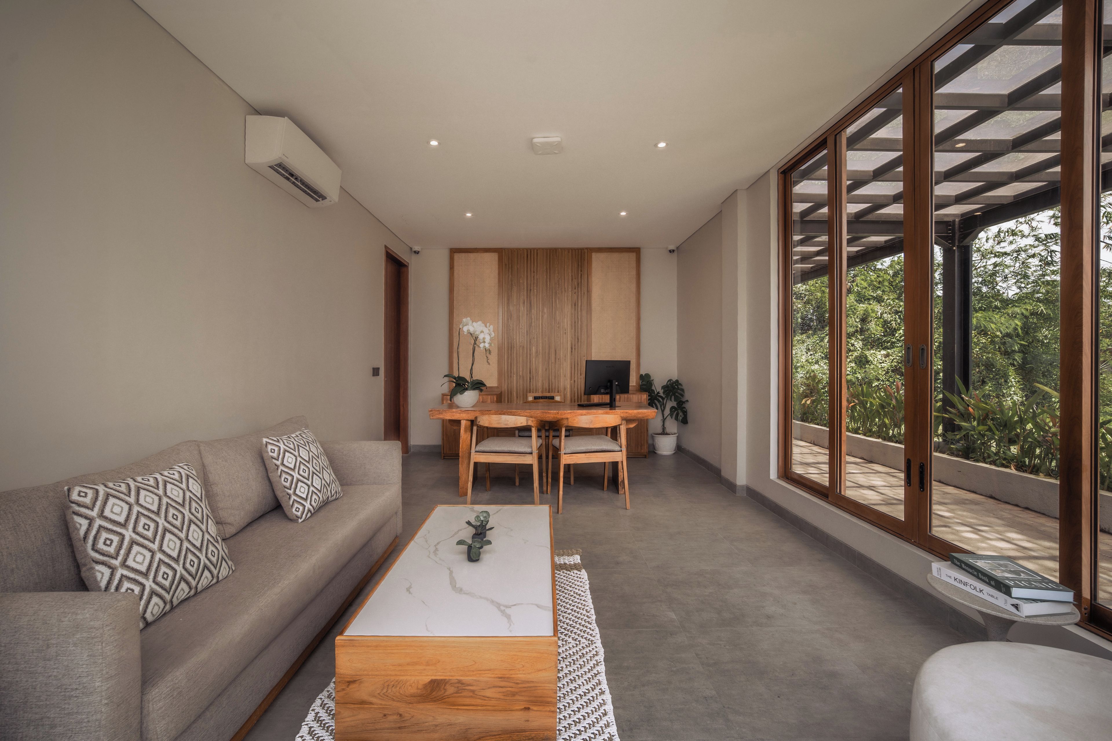 A modern living room with a sofa, coffee table, and dining area.