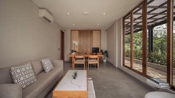 A modern living room with a sofa, coffee table, and dining area.