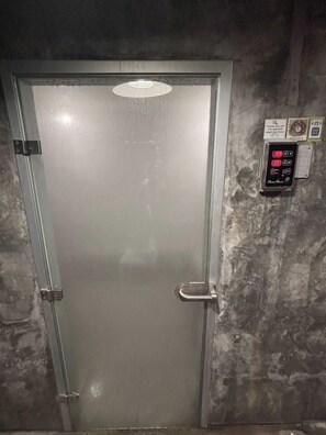 Een metalen liftdeur met een hendel en een bedieningspaneel met knoppen.