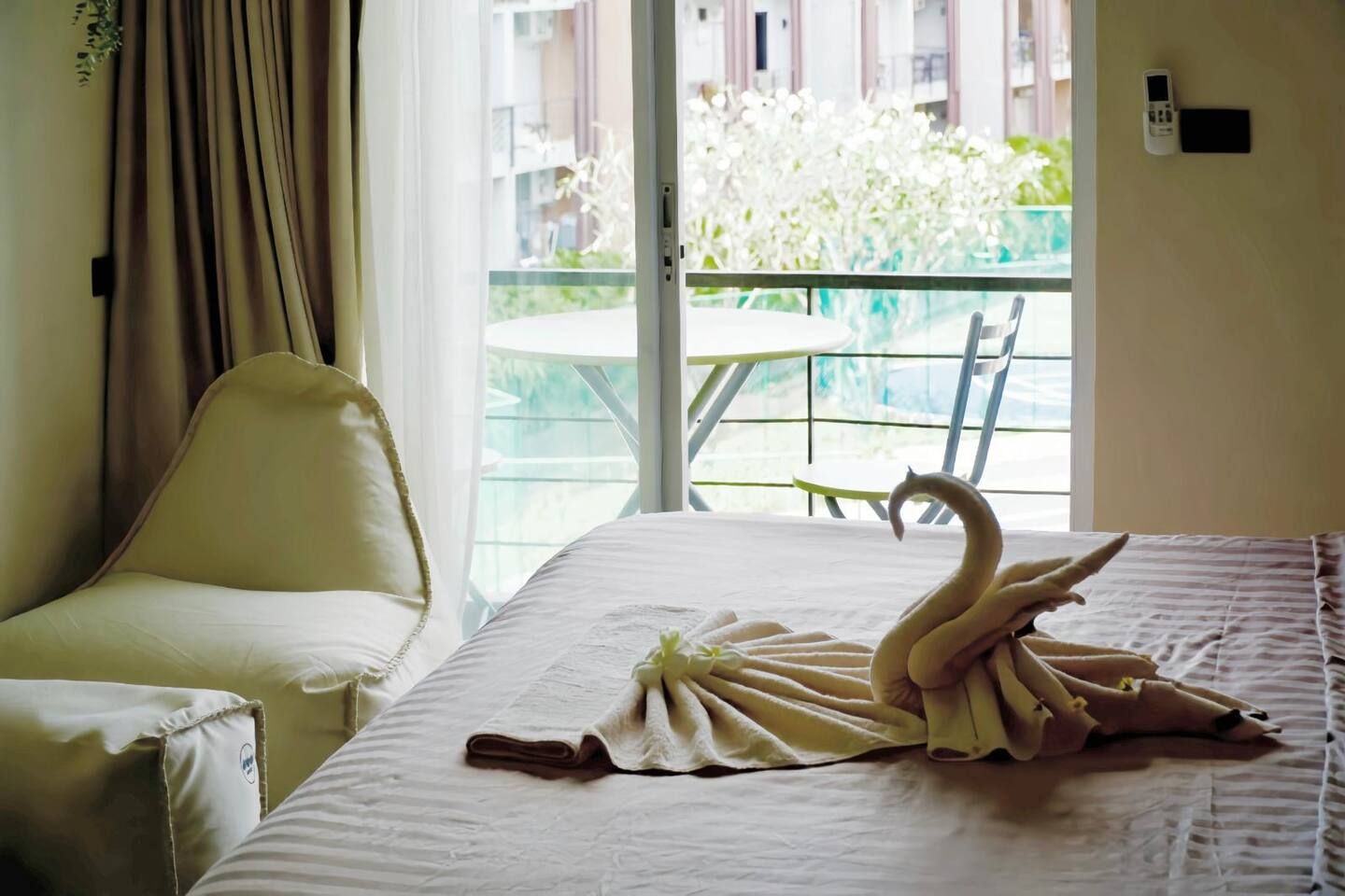 Une chambre d’hôtel avec un lit, une chaise et un balcon équipé d’une table et de chaises.