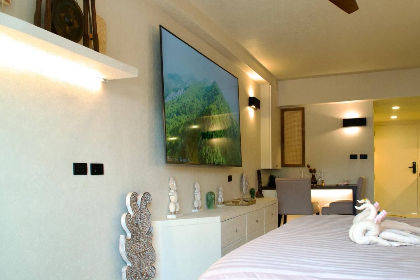 Ein modernes Schlafzimmer mit einem Bett, einem Schreibtisch, einem Stuhl und einem großen Gemälde an der Wand.