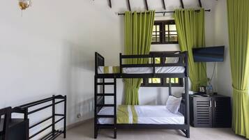 Camera con letto a castello, televisione, scrivania e finestra con tende.