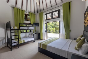 A room with bunk beds, a bed with pillows, a television, and a window with curtains.
