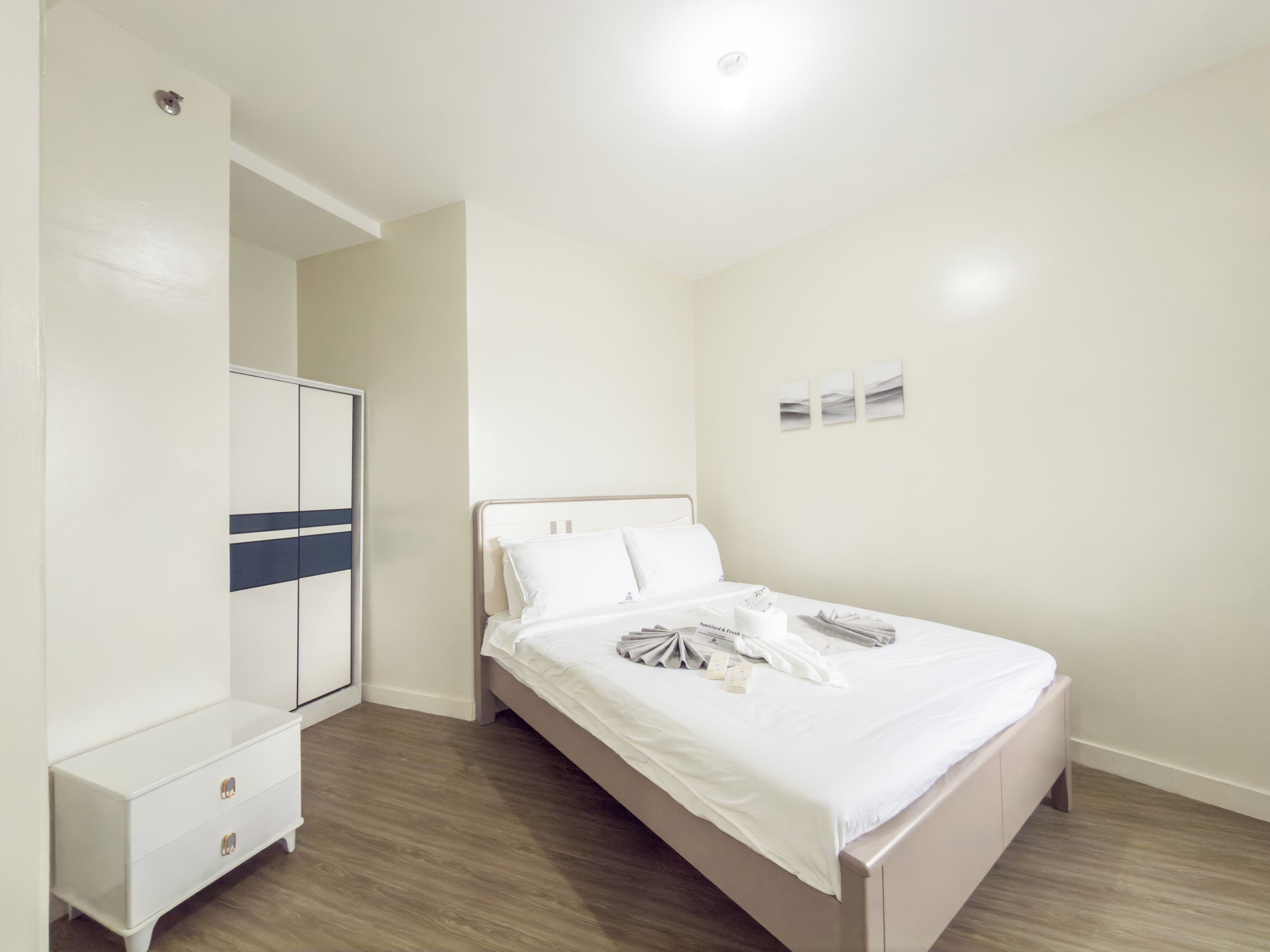 A bedroom with a bed, a wardrobe, and a nightstand.