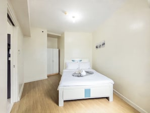 Une chambre d’hôtel avec un lit, une armoire et une porte donnant sur une autre pièce.