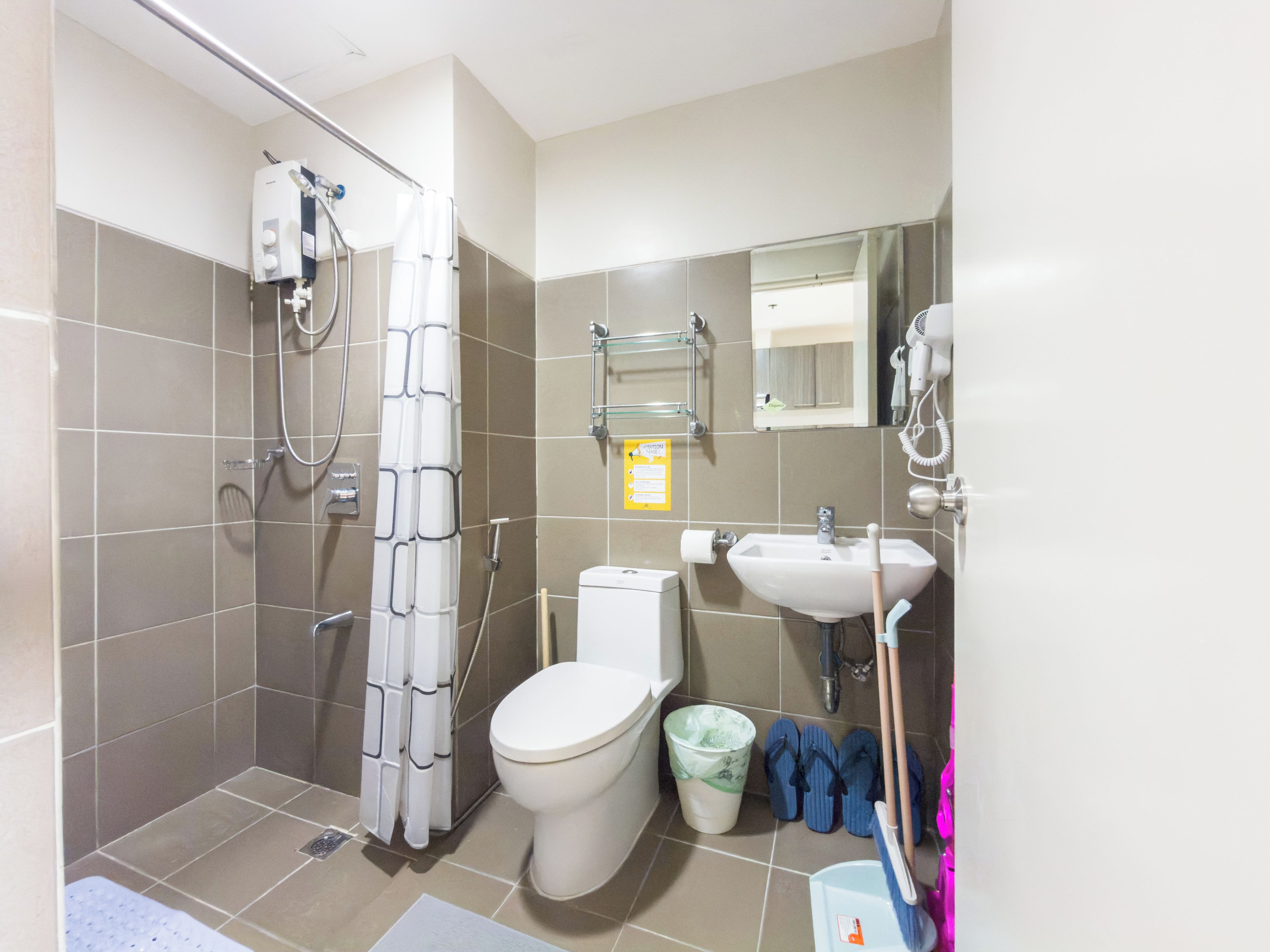 Ein Badezimmer mit Dusche, Toilette, Waschbecken und Spiegel.