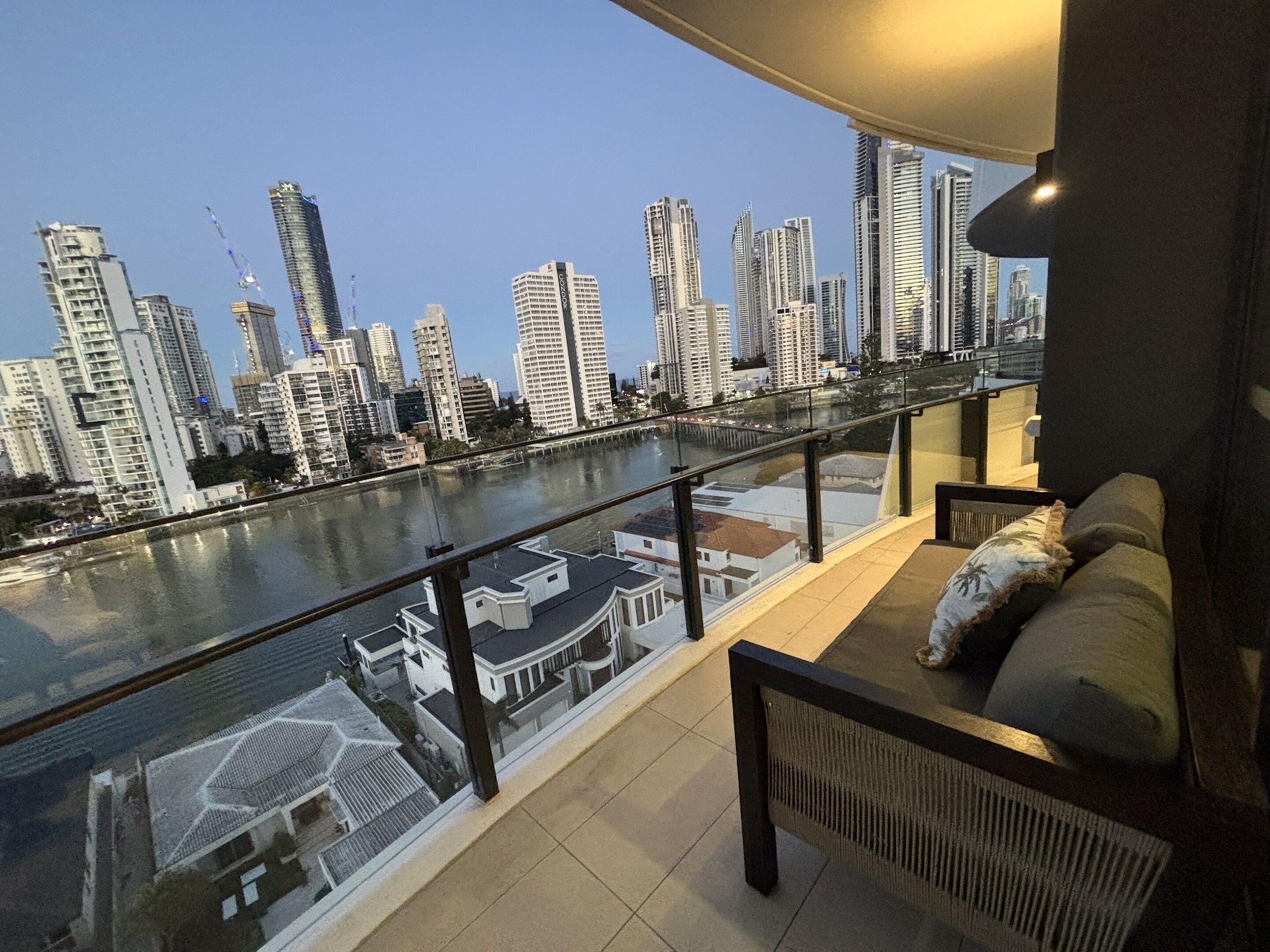 A balcony with a view of a city skyline and a river.