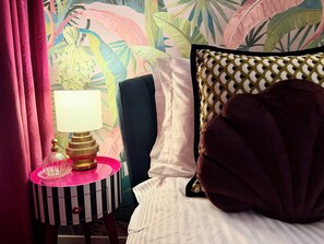 A bed with white bedding, a dark headboard, and a patterned pillow. - Sarcelle - Noumea 18th Floor Refined Apartment with Sea and Mountain views (Nouméa)
