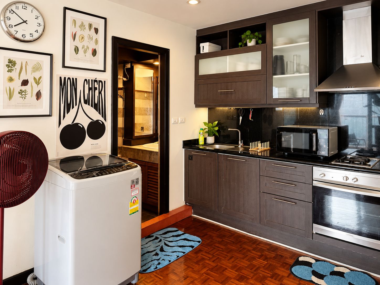 A compact kitchen with a refrigerator, microwave, stove, and cabinets.