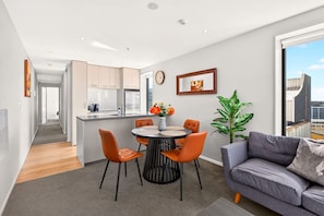 A modern apartment with a dining area, a living room, and a kitchen. - Cosy 2BR in the heart of CBD + Balcony Zodiak Stay (Auckland)