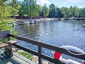 A wooden dock with a bench, a row of boats, and a calm water body. - Yngvesväg 3 by Interhome (Bolmsö)