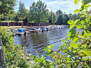 A marina with boats docked, surrounded by trees and a clear sky. - Yngvesväg 3 by Interhome (Bolmsö)