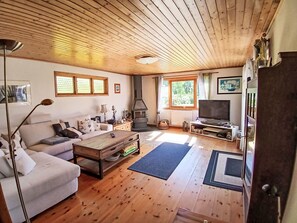 A cozy living room with a sofa, coffee table, TV, fireplace, and wooden floors. - Yngvesväg 3 by Interhome (Bolmsö)
