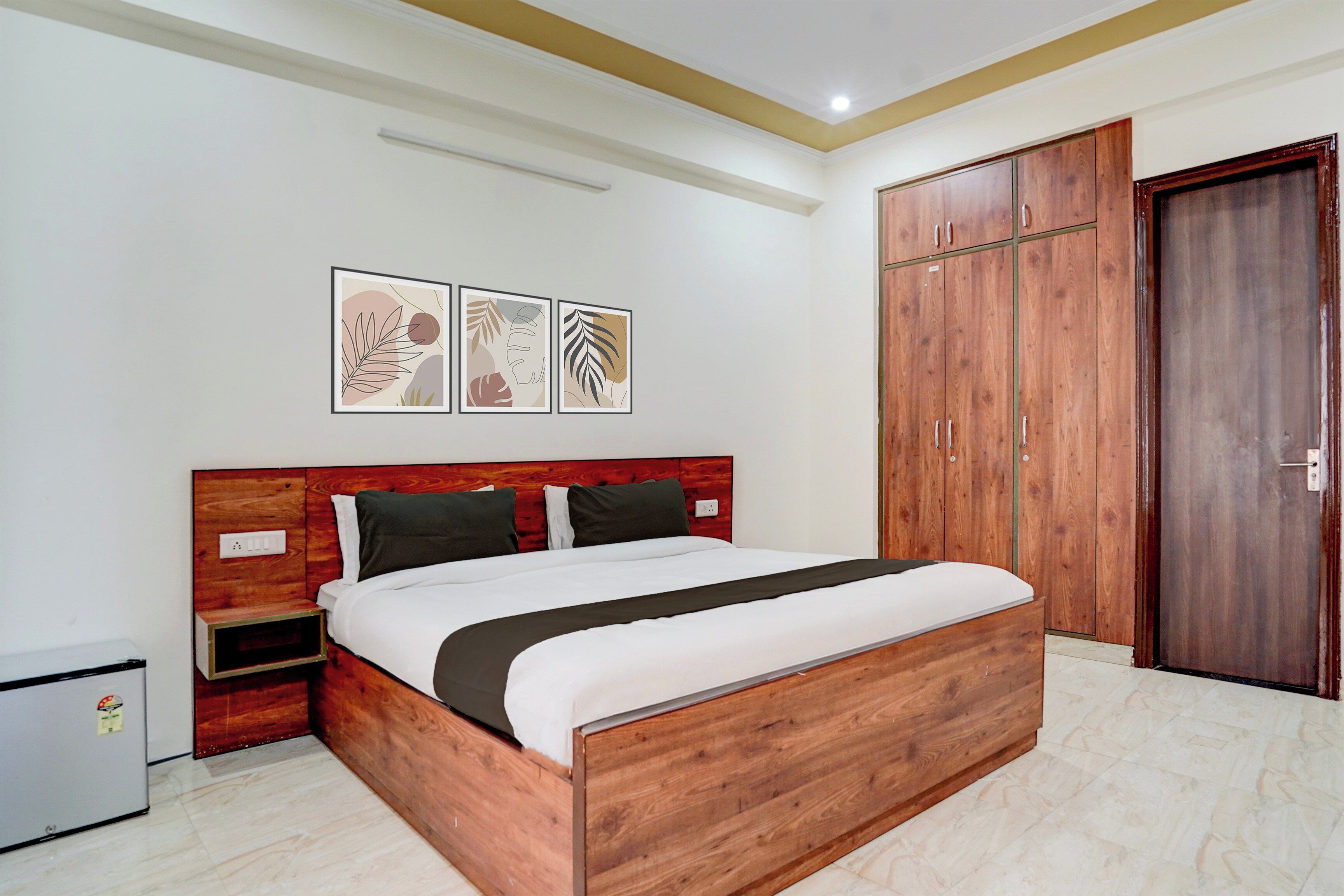Un dormitorio con una cama de madera, un armario y una mesita de noche.