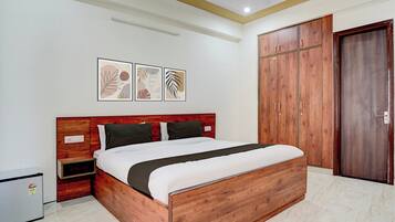 Un dormitorio con una cama de madera, un armario y una mesita de noche.