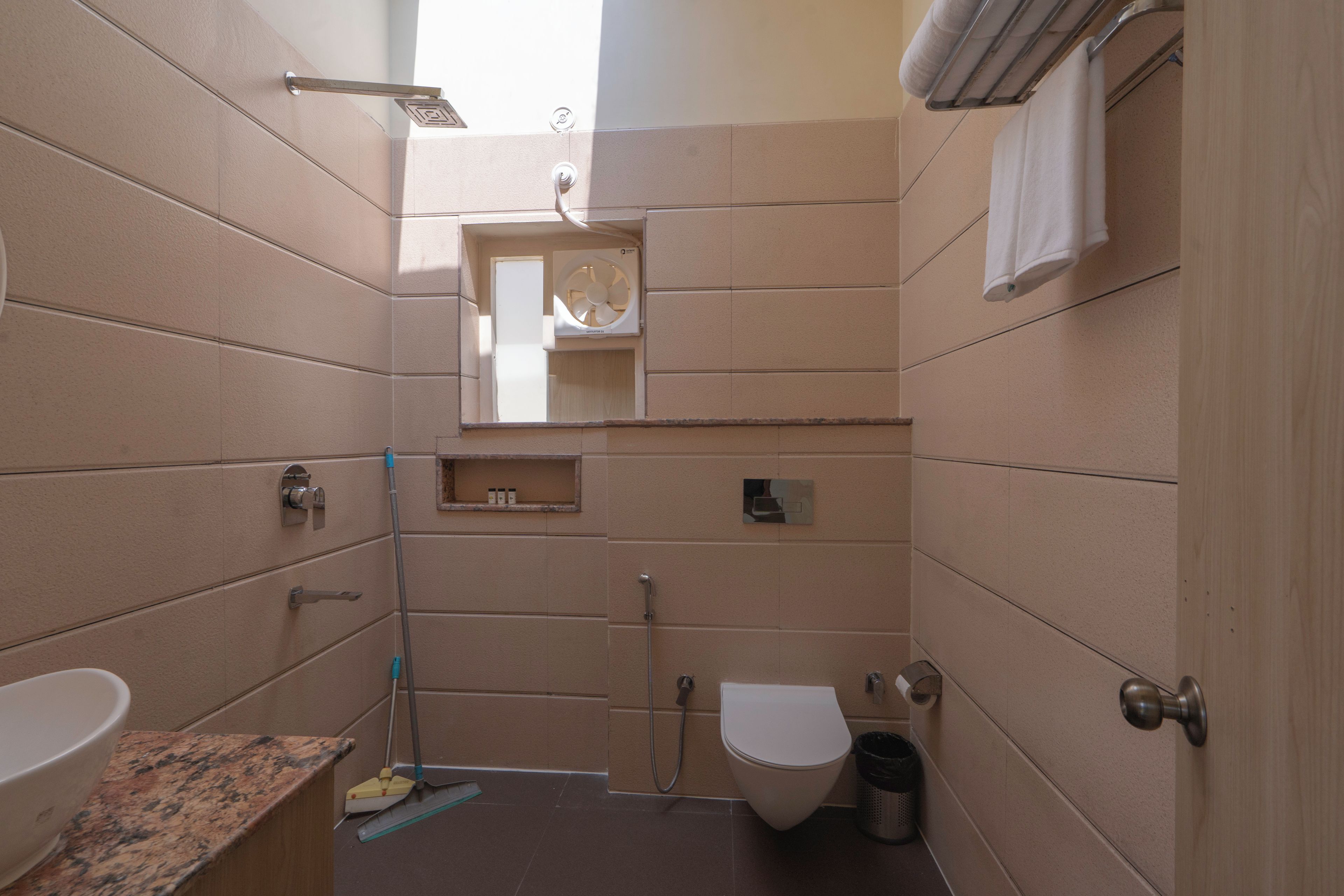 A compact bathroom with a toilet, sink, and shower.