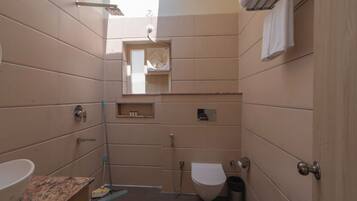A compact bathroom with a toilet, sink, and shower.