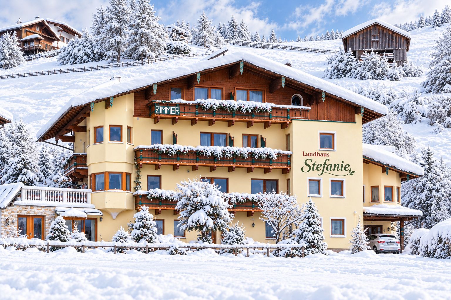 A multi-story hotel with a wooden facade, balconies, and a sign that reads 'Landhaus Stefanie.'