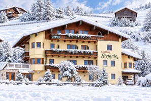 A multi-story hotel with a wooden facade, balconies, and a sign that reads 'Landhaus Stefanie.'