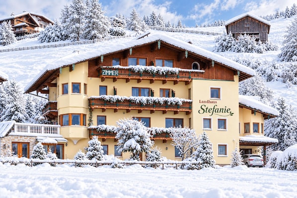 A multi-story hotel with a wooden facade, balconies, and a sign that reads 'Landhaus Stefanie.'
