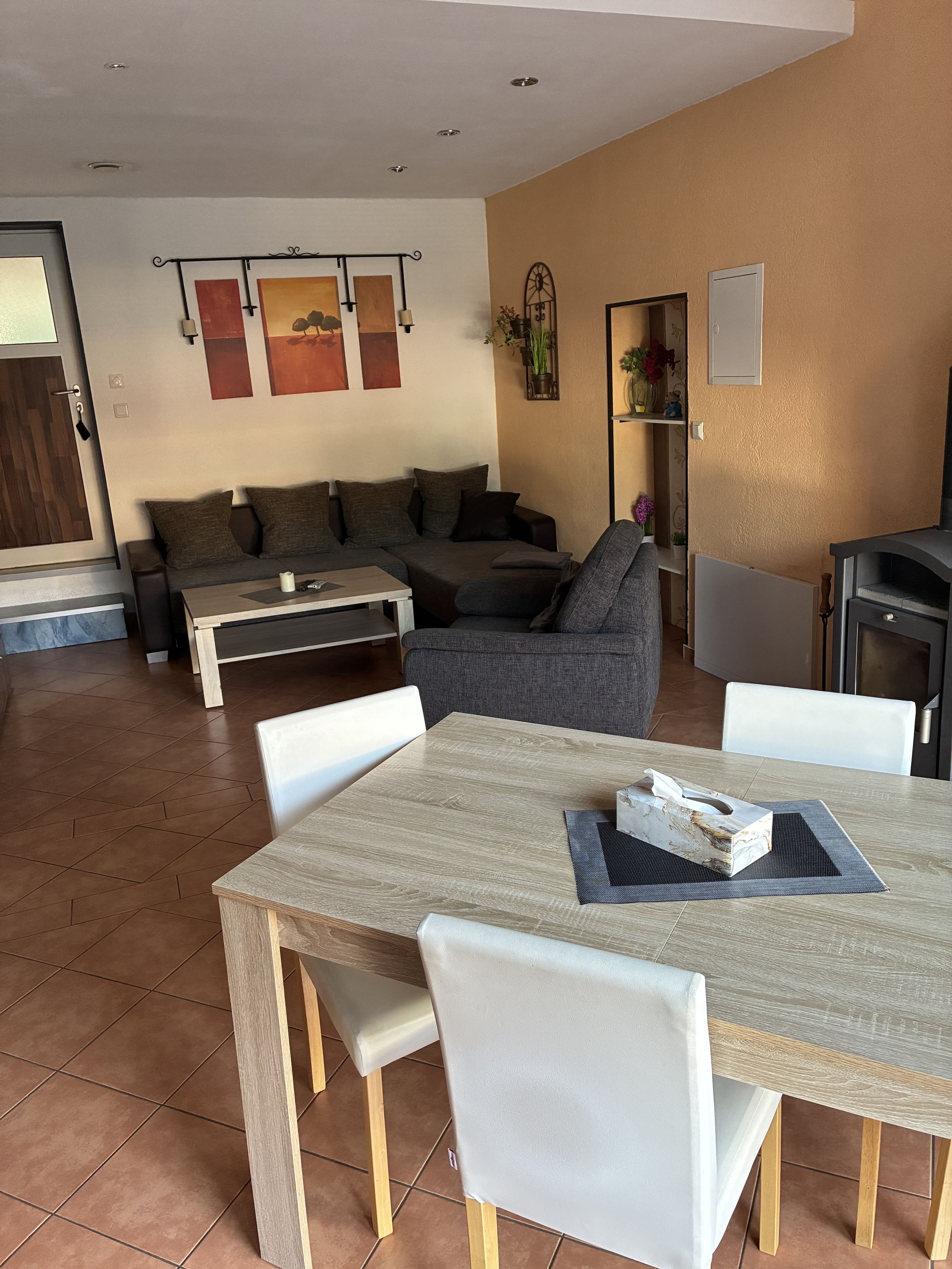 A modern living room with a sofa, a coffee table, and a dining table with chairs.