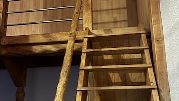 A wooden staircase with metal handrails, leading to an upper level.
