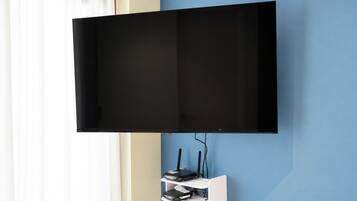 A flat-screen TV mounted on a wall with a cable management box below it.