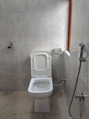A bathroom with a toilet, a shower, and a hand dryer. - Cozy Retreat Homestay mountain view homestay in Bijonbari-Darjeeling| Organic. (Goke)
