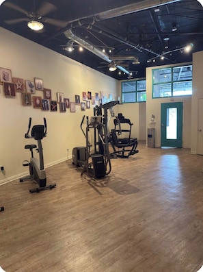 A gym with exercise equipment, wooden flooring, and artwork on the walls. - Casa Sol e Mare Beachfront Getaway by Redondo Pier (Redondo Beach)