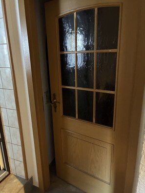 Eine Holztür mit Glasschiebeelement und Messinggriffen.