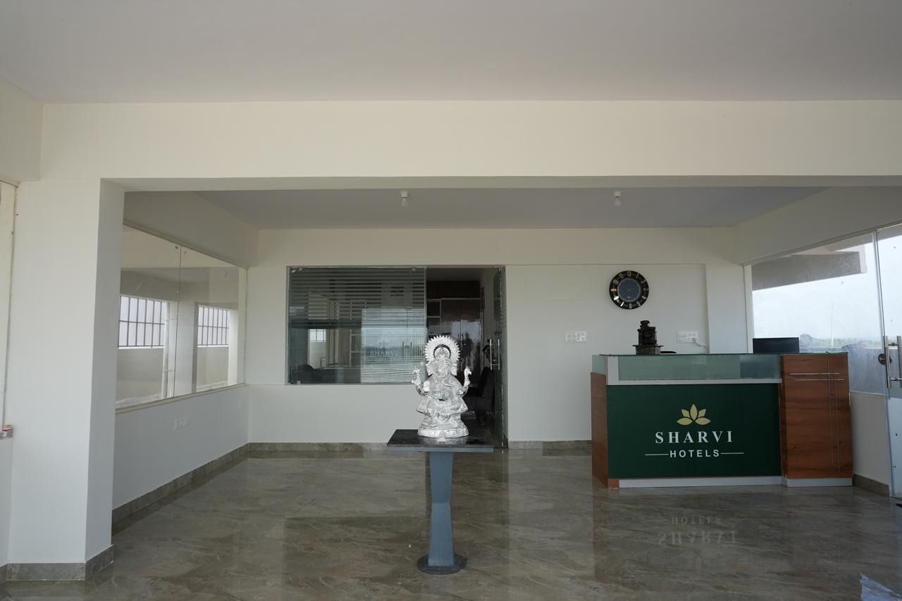 Zona de recepción con mostrador, un reloj y una estatua.