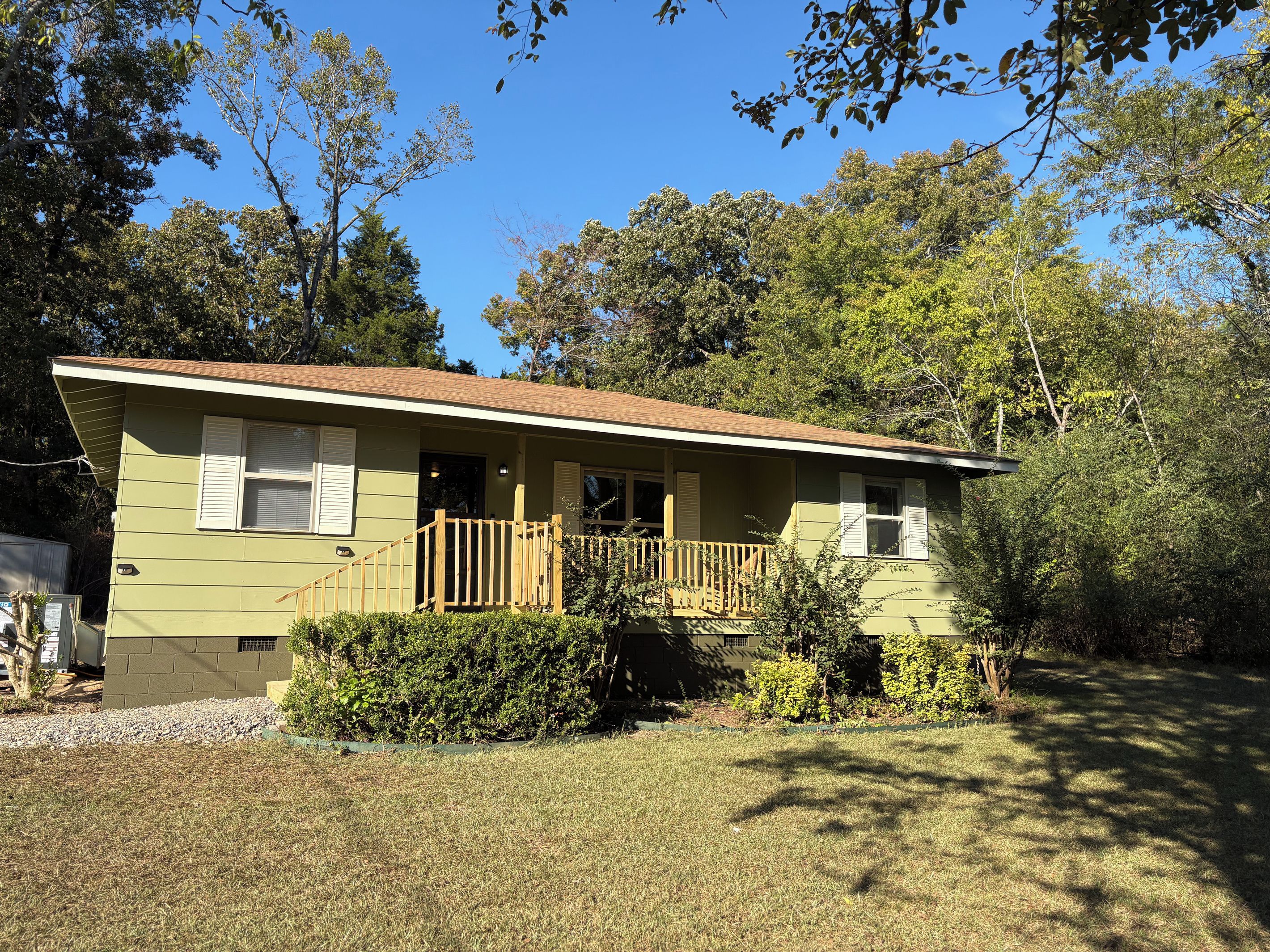 A single-story house with a front porch, a small front yard, and a garage.