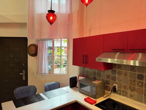 A kitchen with red cabinets, a microwave, and a gas stove. - Loft (double-height) on the boardwalk, half a block from the beach (Puerto Vallarta)