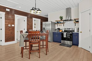 Eine moderne Küche mit einem Edelstahl-Kühlschrank, einem Herd und blauen Schränken.