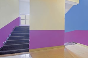 A staircase with a handrail, leading to a landing with a window.