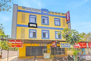 Un edificio de varios pisos con un letrero llamativo que dice 'OYO', indicando un hotel o establecimiento de hospedaje.