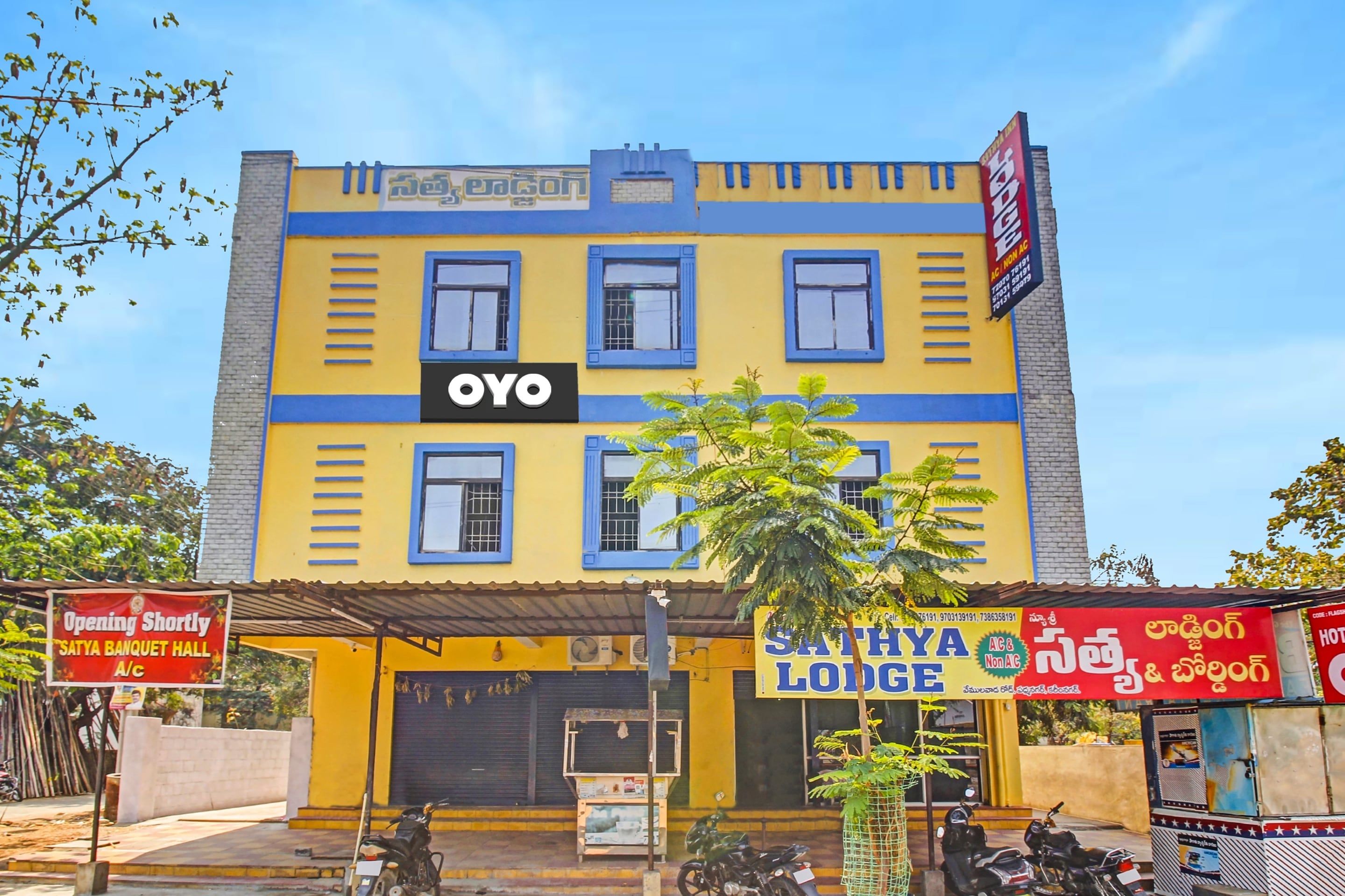 Un edificio de varios pisos con un llamativo letrero 'OYO', que indica un hotel o establecimiento de hospedaje.